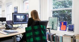 Office worker sat in front of a desk and computer